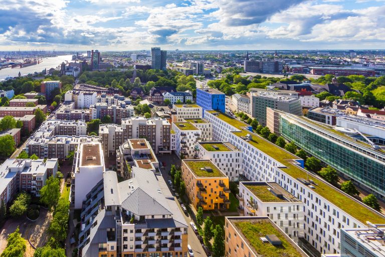 Luftaufnahme von Hamburg mit modernen Wohngebäuden und Blick auf die Stadt.