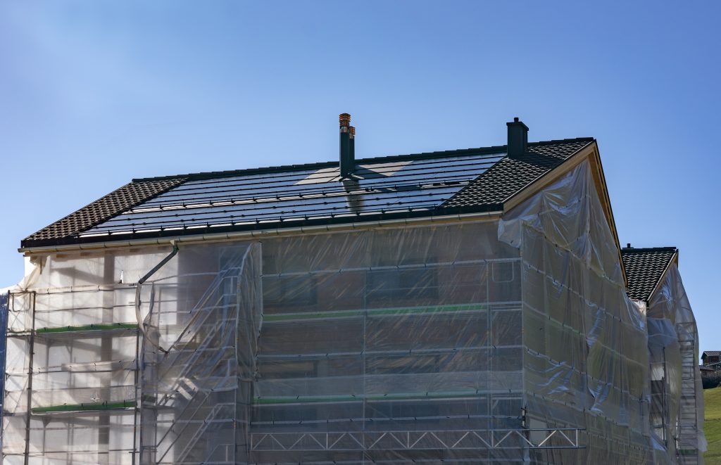 Gerüst und Planen umhüllen Häuser. Sie werden modernisiert.